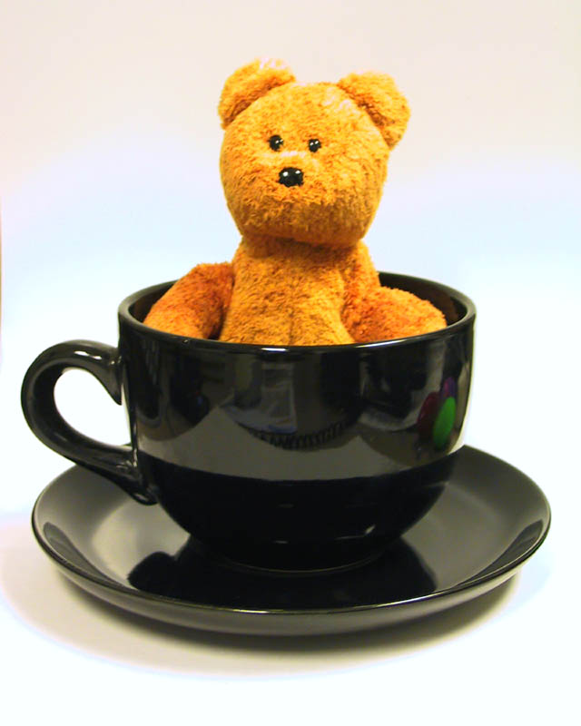 stuffed bear sitting in big mug